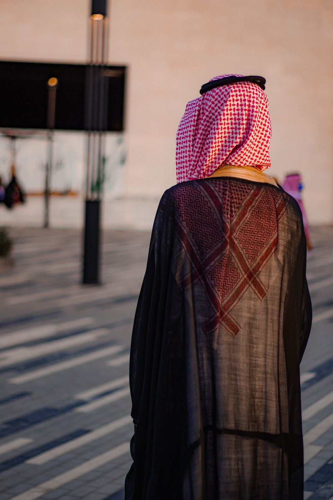 A man in a bisht and shemagh, seen from behind