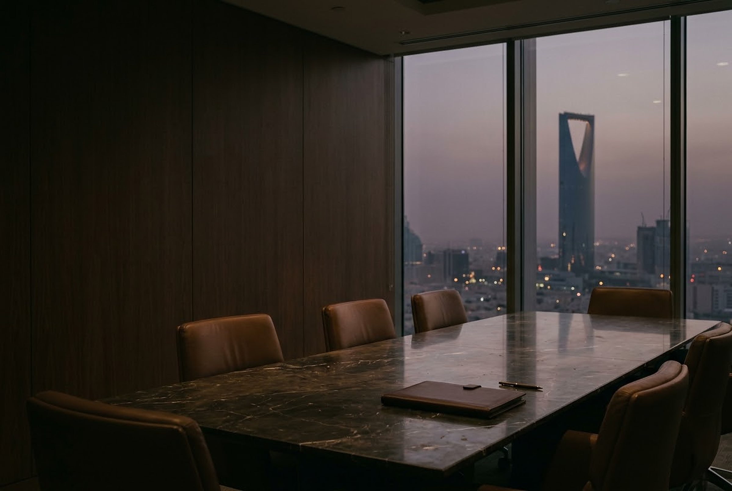 A boardroom at dusk, Kingdom Centre in the window
